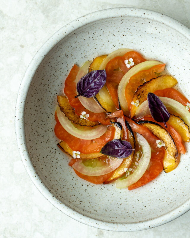 Tomato – Tosazu – Vanilla 🍅  We’re clinging to the very last breath of summer. The tomatoes are just about done for the season, but we’ve managed to get our hands on these sun-ripened beauties.  We slice them fresh, then layer them with grilled nectarines for sweetness and depth, and green tomatoes we’ve pickled gently with vanilla for a subtle floral twist. A drizzle of strawberry balsamic ties it together with just a hint of fruit and acidity.  Finally, we pour over a clear tomato water, seasoned with tosazu (soy, rice vinegar, and dashi) adding umami and that sharp, refreshing lift that makes the whole dish sing.  It’s summer in its last notes